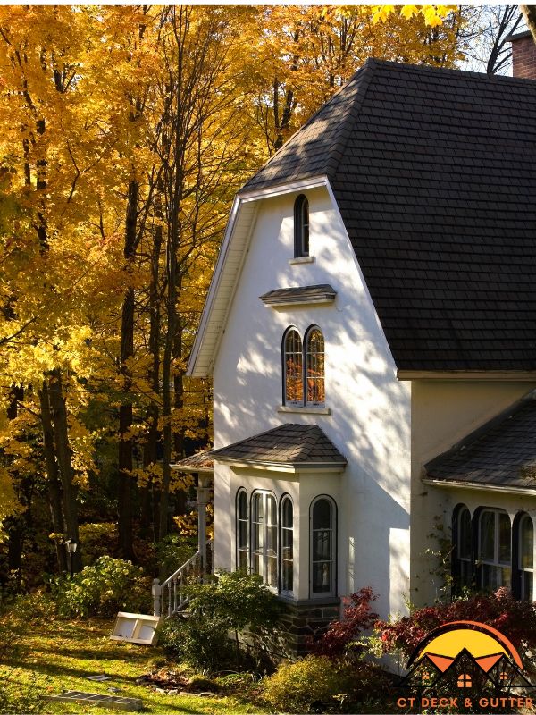 Image of an elegant White House with dark room during autumn in Connecticut for an article about autumn home maintenance tips.
